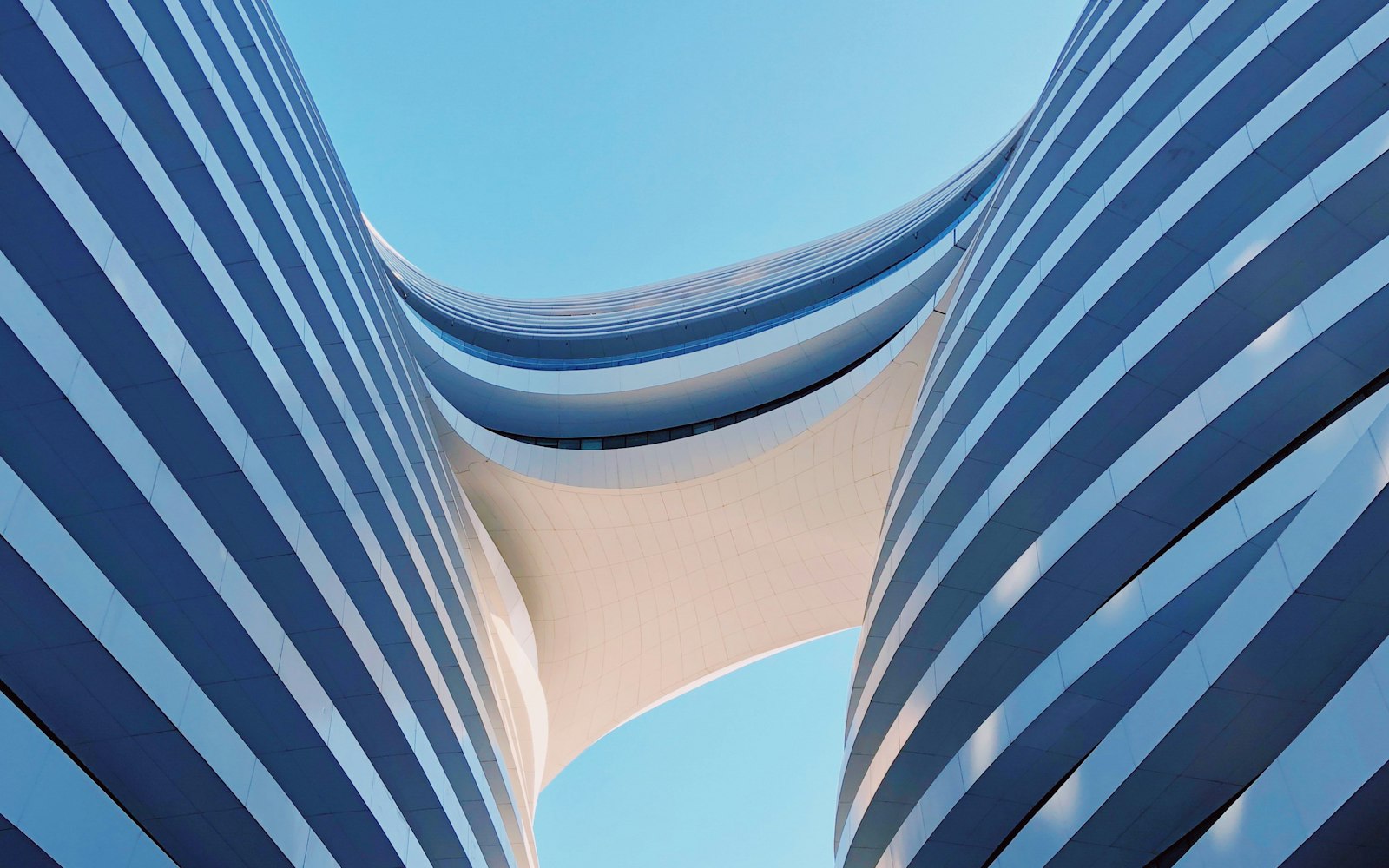 A sculptural high-rise facade against a blue sky