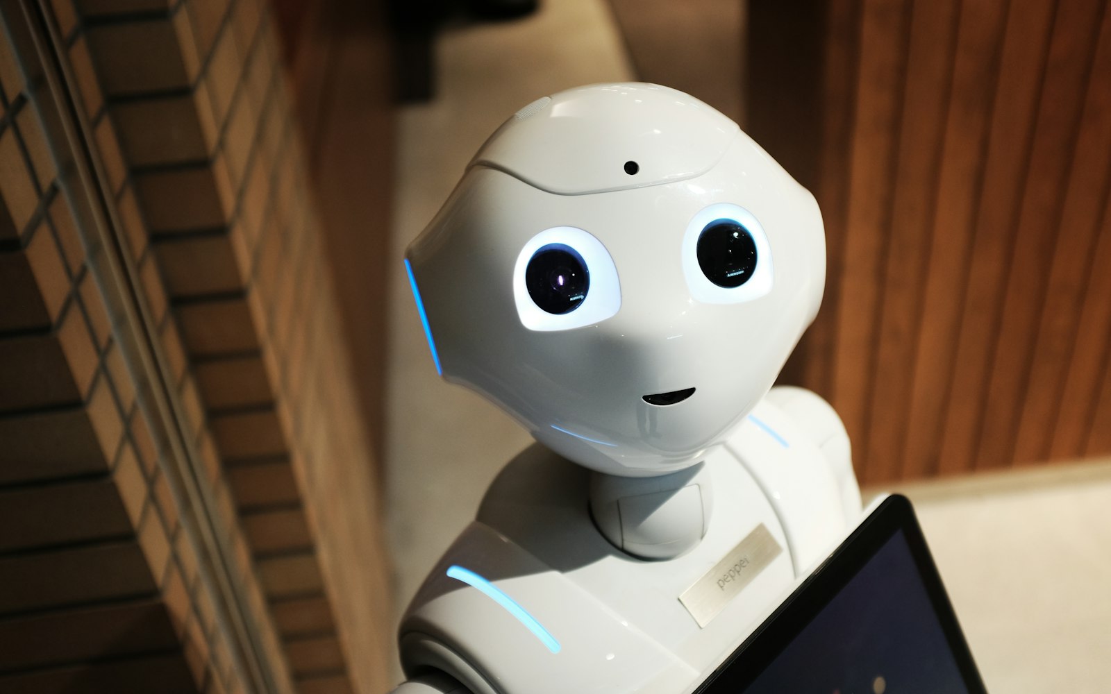 A white humanoid robot standing in a workshop