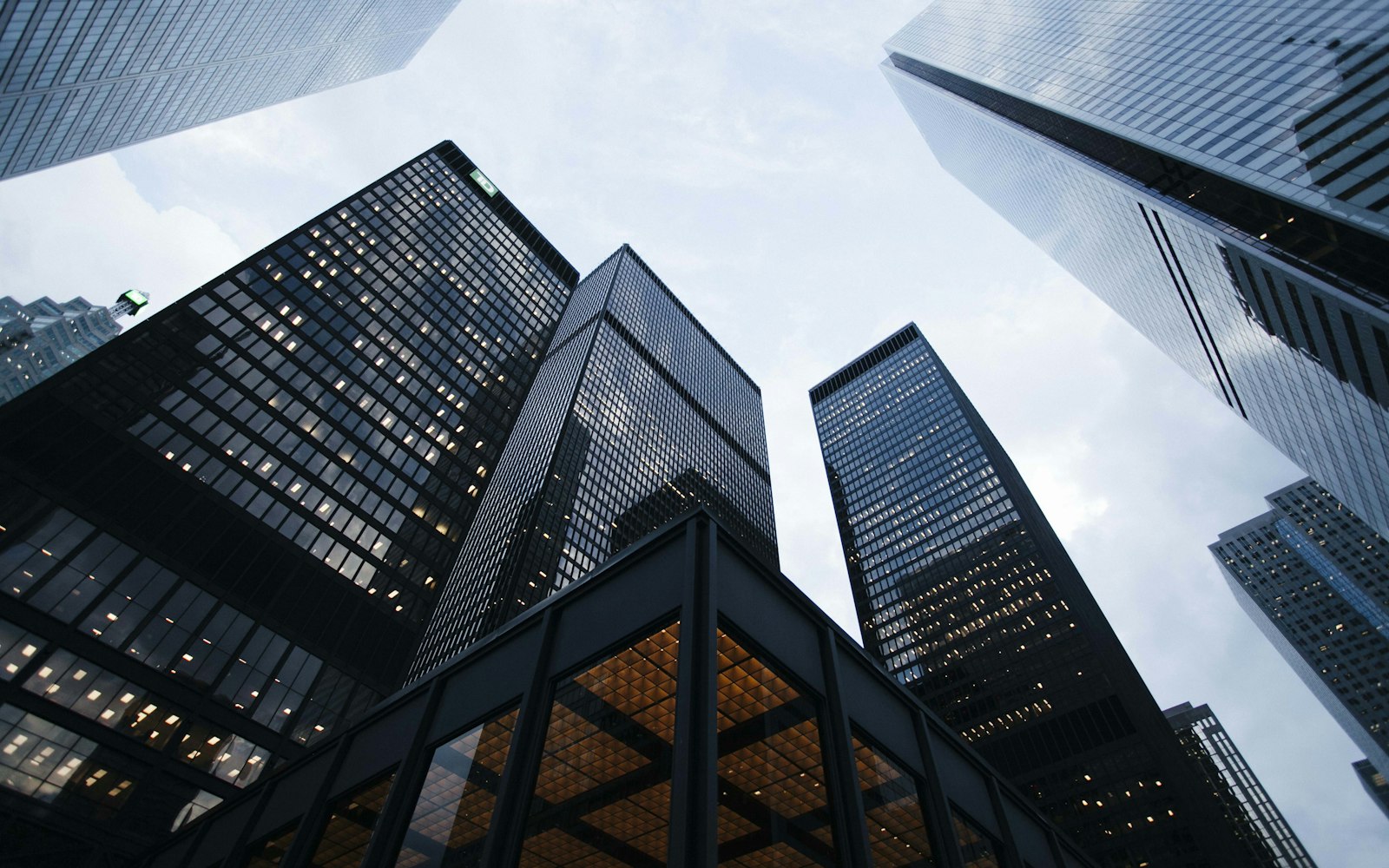 Tall buildings viewed from a low angle against a grey sky
