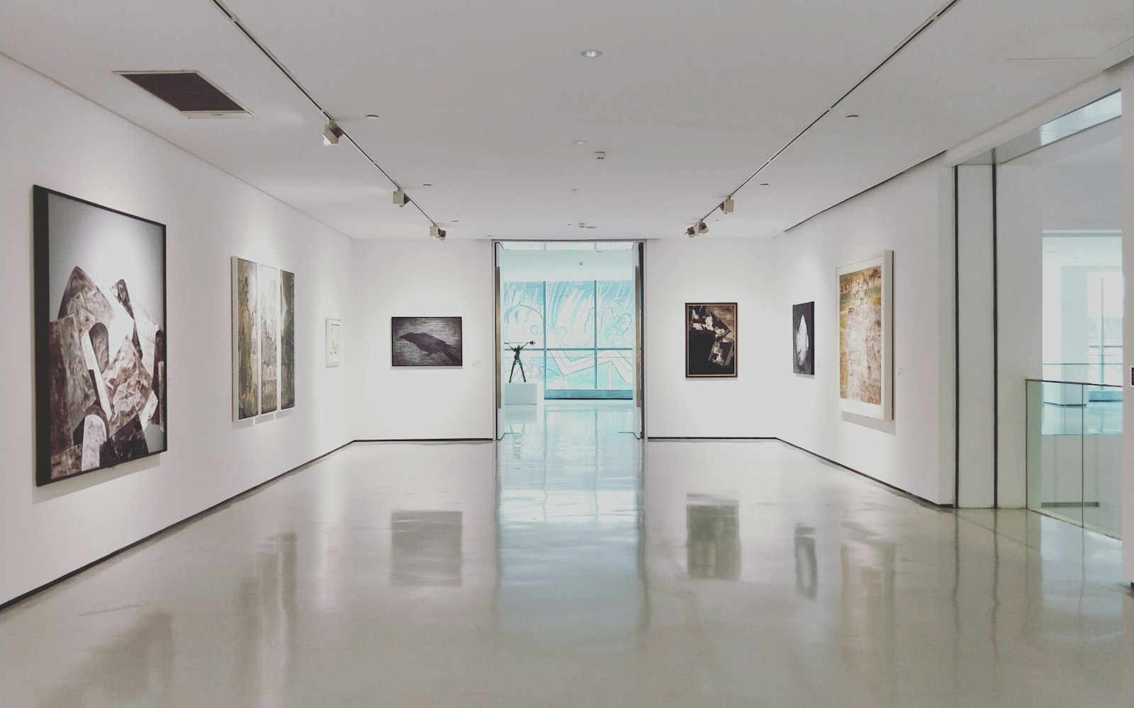 A bright modern art gallery with framed works on white walls